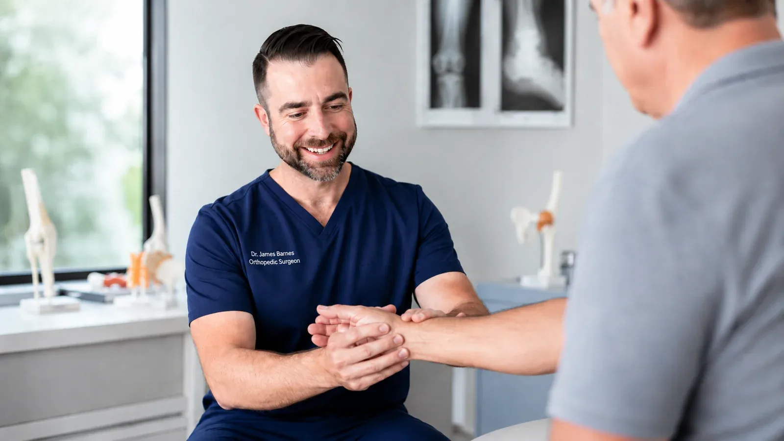 Dr. James Barnes examining a patient’s hand and wrist in a modern orthopedic clinic