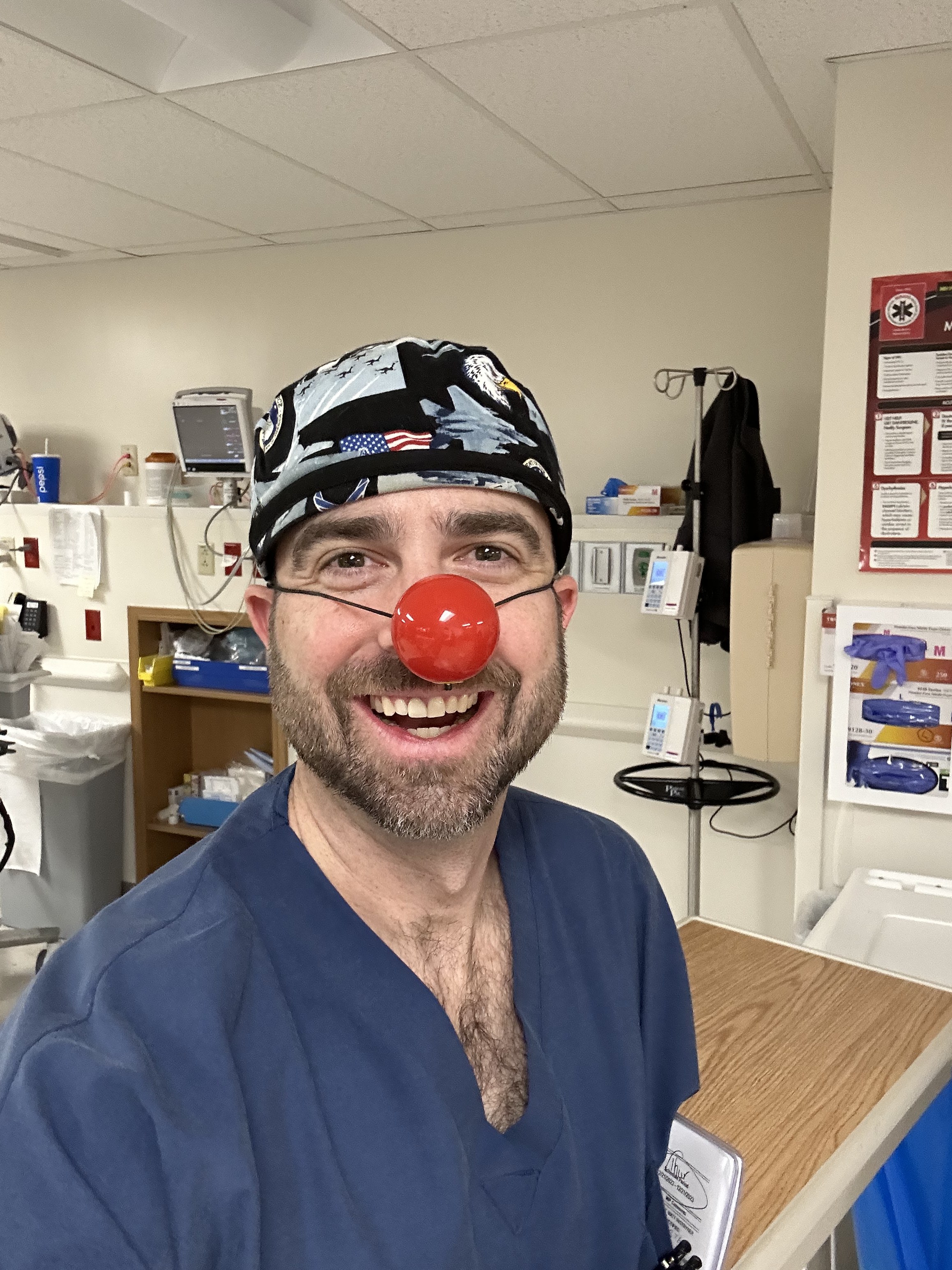 Dr. Barnes in scrubs and scrub cap with a red clown nose, showing the lighter side of surgical care
